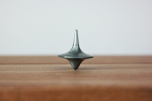 机の上に金属製のコマが回っている様子